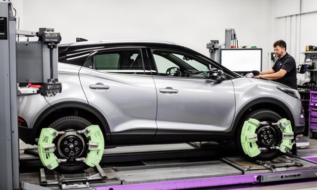 Vehicle positioned on a professional wheel alignment machine inside an automotive workshop