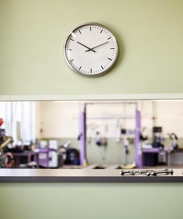 Wall clock above a tidy automotive service counter during opening hours